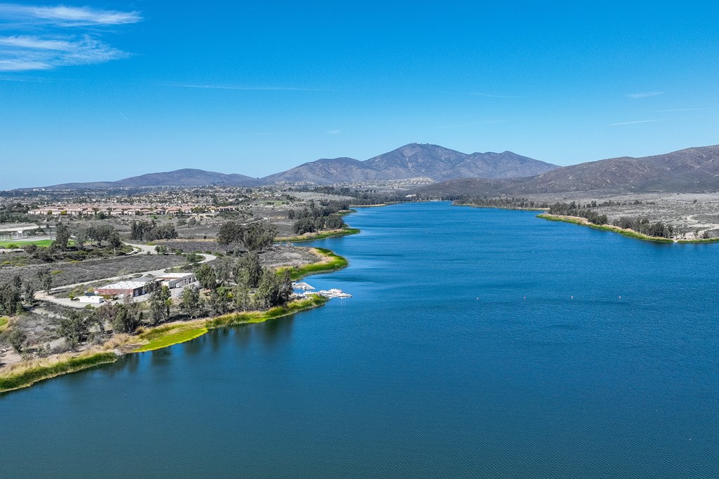 A large body of water surrounded by greenery and mountains.