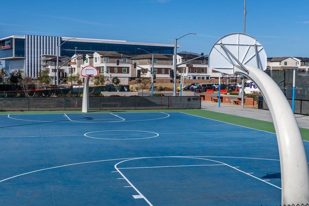 A basketball court with a hoop and a sign on the ground.