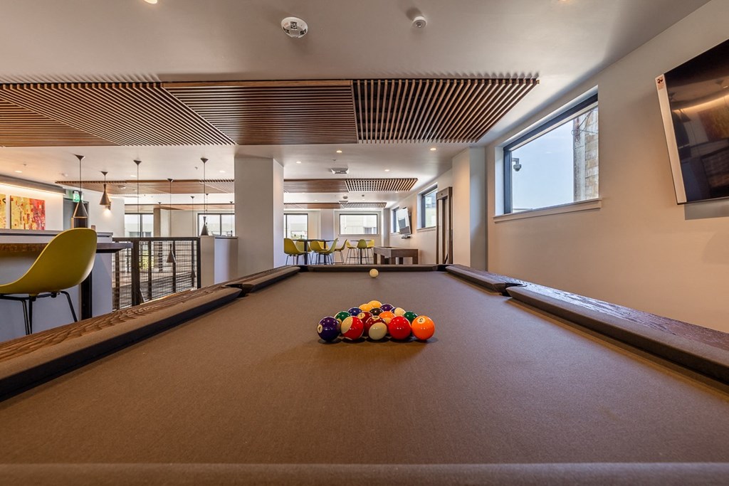 a pool table in the lobby of a building with balls on it