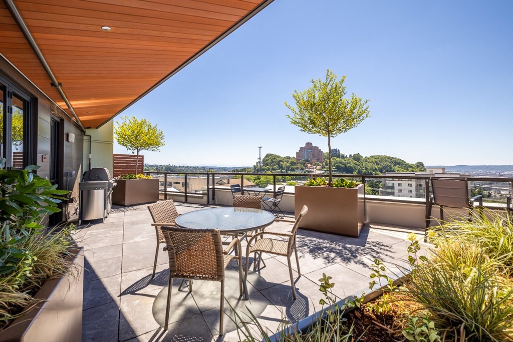 a balcony with a table and chairs and a view of the city