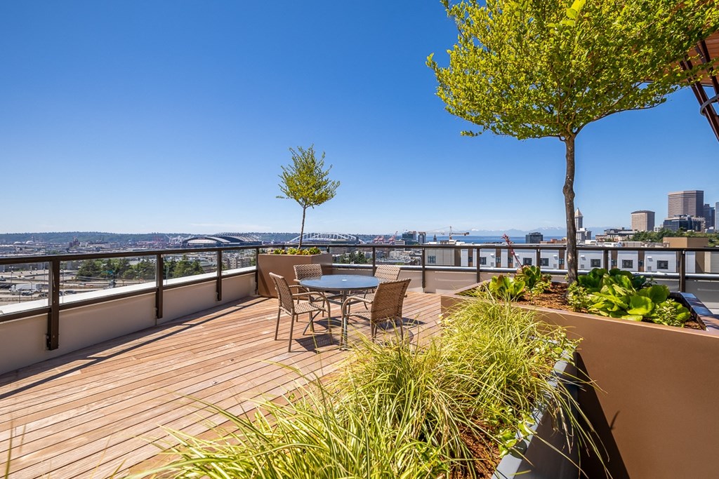 a deck with a table and chairs and a view of the city