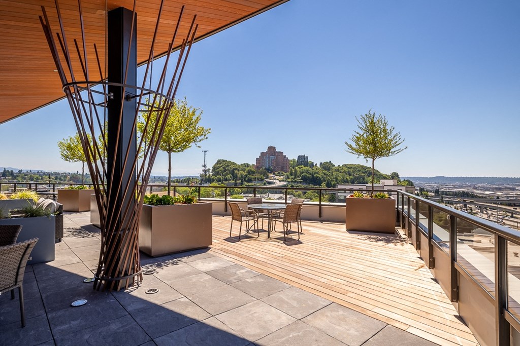 a roof deck with tables and chairs and a view of the city