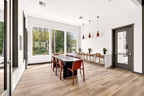 A dining room with a long table and chairs.
