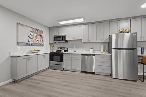 A modern kitchen with a refrigerator, oven, and microwave.