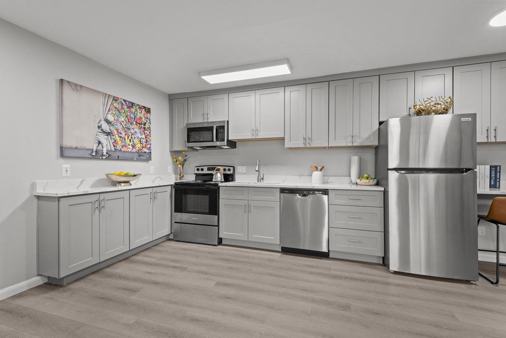 A modern kitchen with a refrigerator, oven, and microwave.