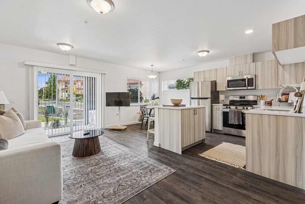 A modern kitchen with a white sofa and wooden cabinets.