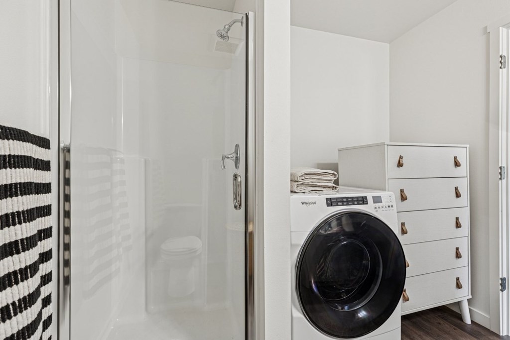 A black and white striped towel hangs on a glass door.