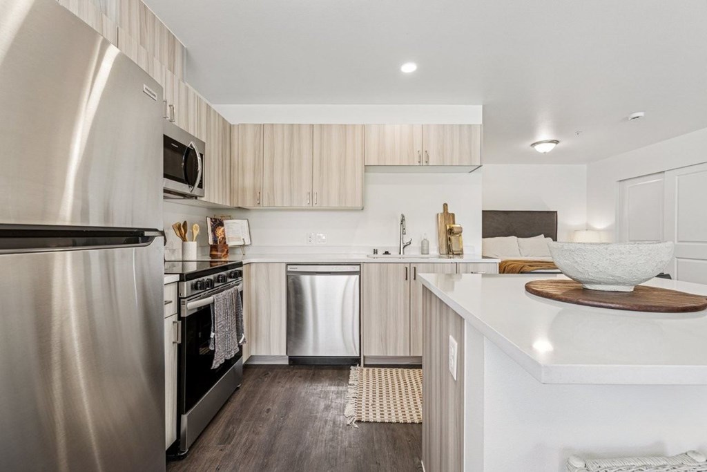 A modern kitchen with a stainless steel refrigerator and a white countertop.