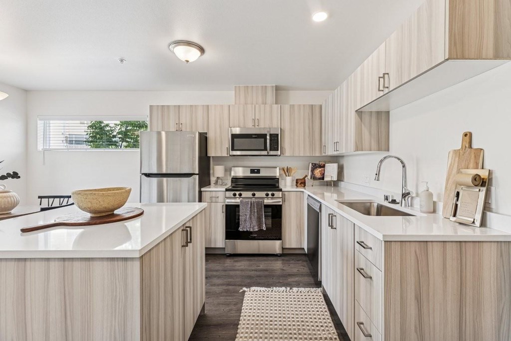A modern kitchen with wooden cabinets and stainless steel appliances.