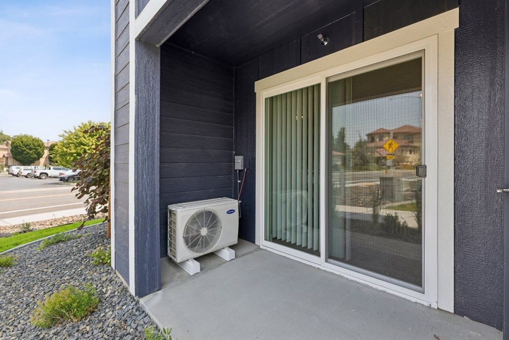 A house with a window and a fan outside.