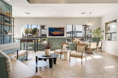 A living room with a large painting on the wall and a view of the outside.