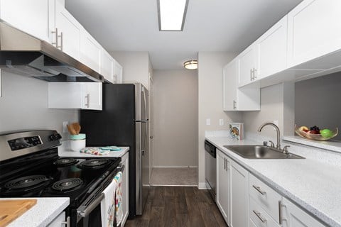 a kitchen with white cabinets and a black stove and refrigerator