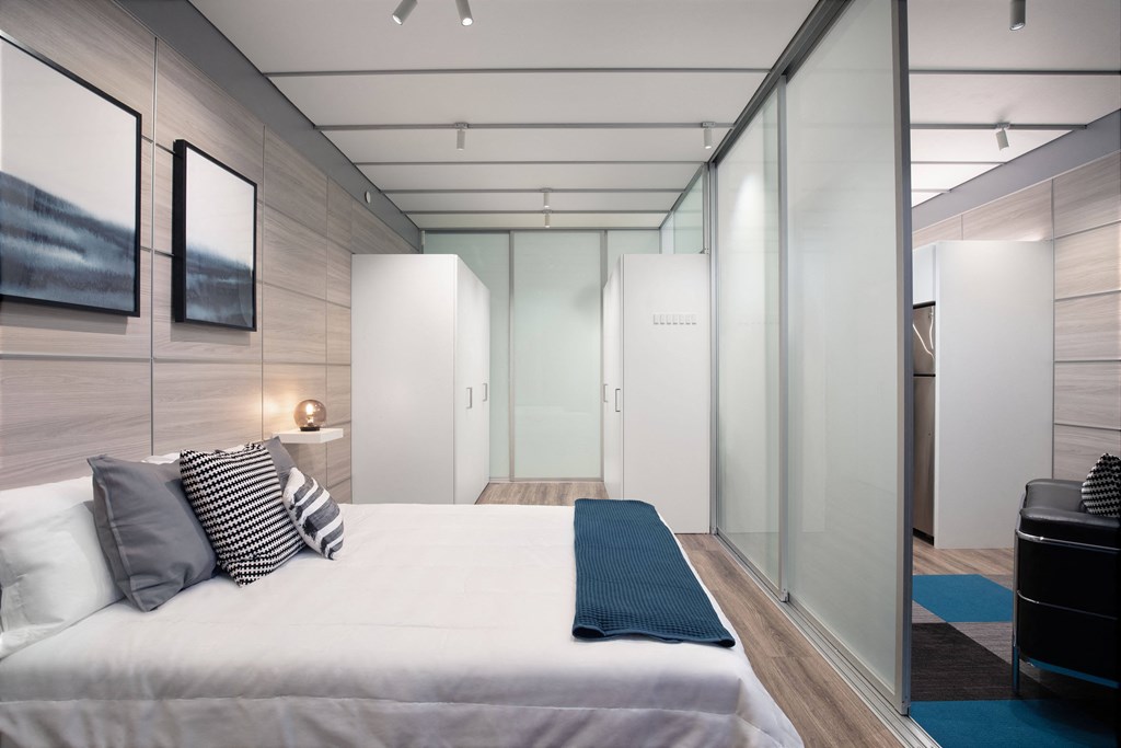 a bedroom with a bed and glass walls