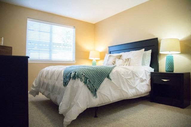 a bedroom with a bed and two lamps