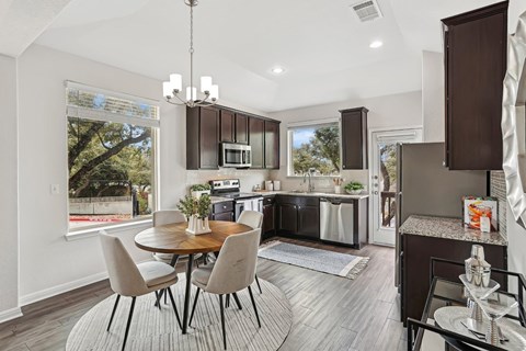 A modern kitchen with a dining table and chairs.