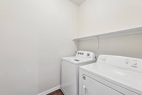 A white washing machine and dryer in a small laundry room.
