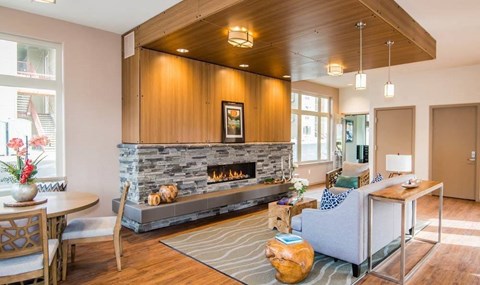 A modern living room with a stone fireplace and wooden accents.