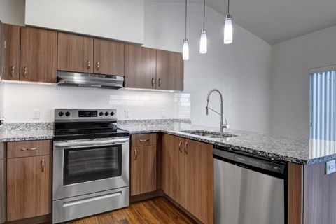 A modern kitchen with wooden cabinets and stainless steel appliances.