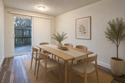 A dining room with a table and chairs.