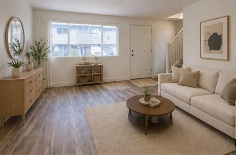 A living room with a white couch and a wooden coffee table.