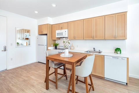 A kitchen with a table and chairs in the middle of the room.