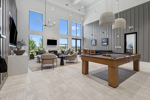 A spacious room with a pool table and a television.