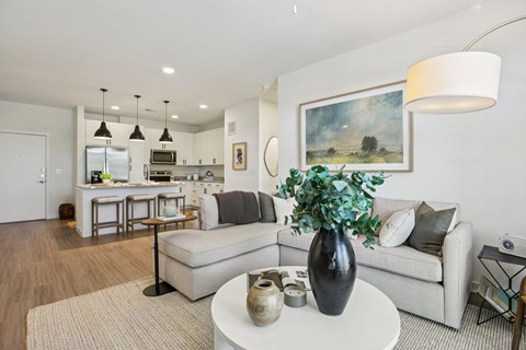 A modern living room with a large painting on the wall and a white sofa.