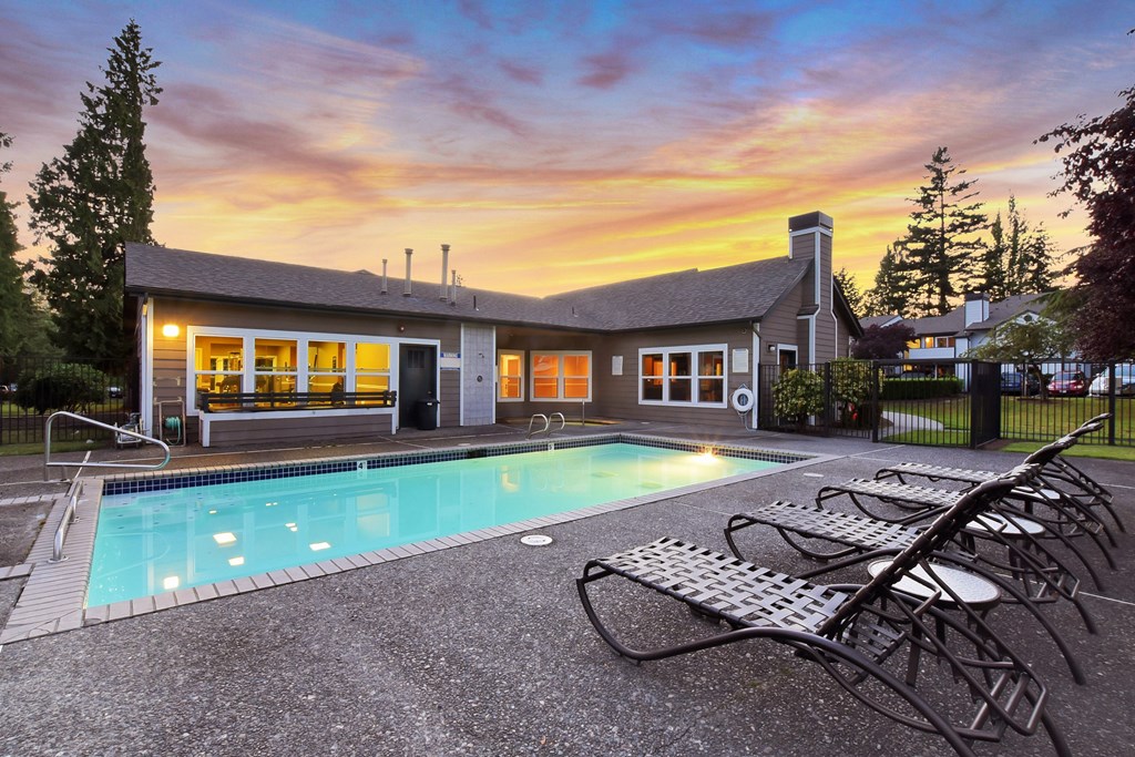 A house with a pool in front of it.