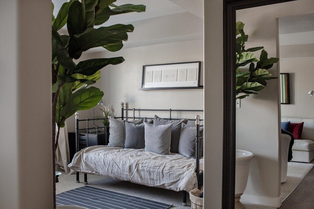 A bedroom with a bed, pillows, and a mirror.