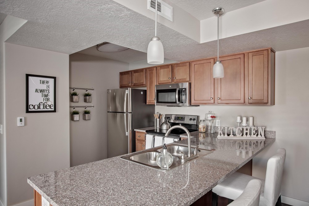 A kitchen with granite countertops and stainless steel appliances.