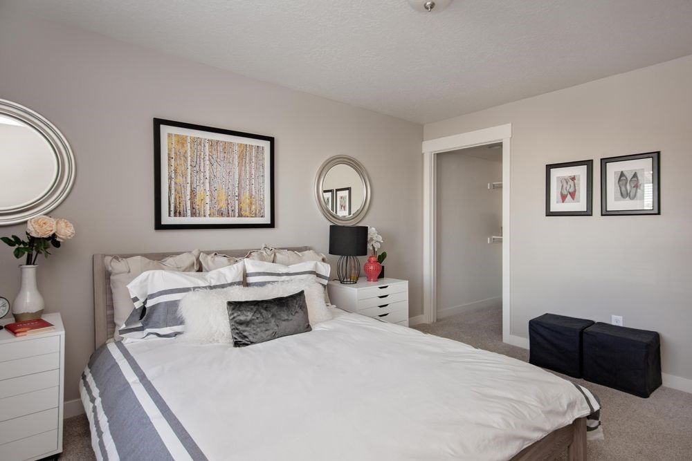 A bedroom with a large bed and two framed pictures on the wall.