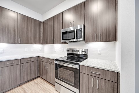 A kitchen with wooden cabinets and a stainless steel oven.
