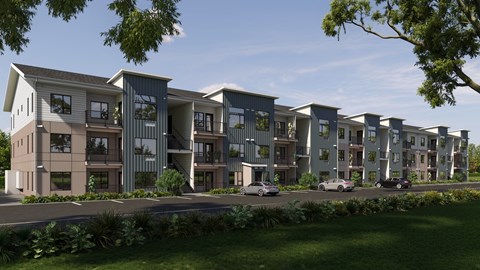 A modern apartment complex with multiple buildings and cars parked in front.
