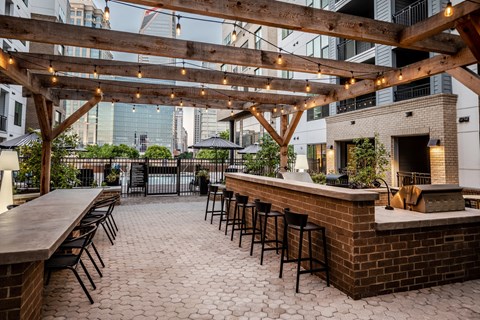 a patio with a brick bar and chairs