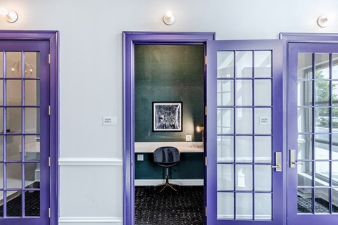 a room with purple doors and a desk with a chair