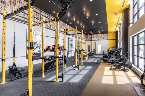 a gym with weights and other exercise equipment and a large window