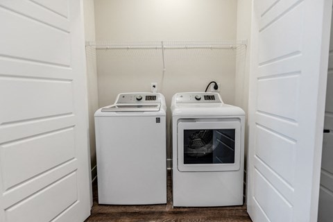 a washer and dryer in a laundry room with white doors