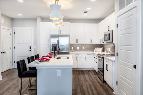 a large kitchen with white cabinets and a white counter top