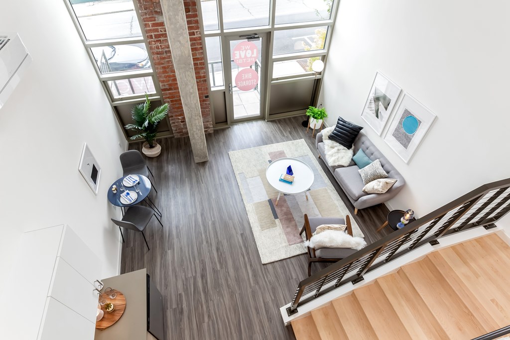 A living room with a couch, a coffee table, and a staircase.