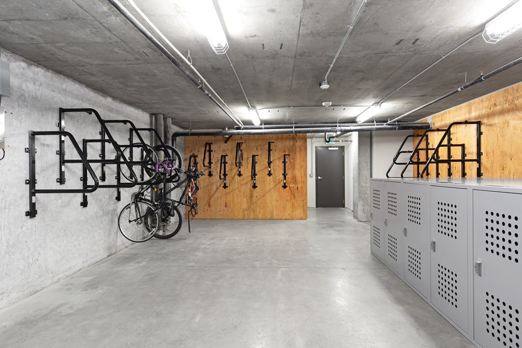 A bike rack with bikes is in a concrete room.