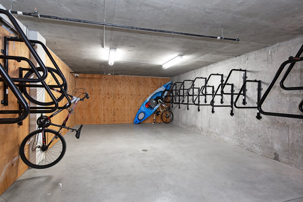 A bicycle is hanging on a rack in a concrete room.