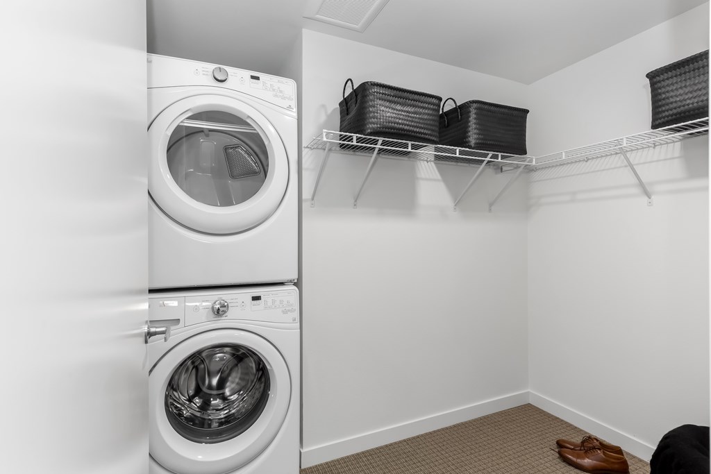 A laundry room with a washer and dryer stacked on top of each other.