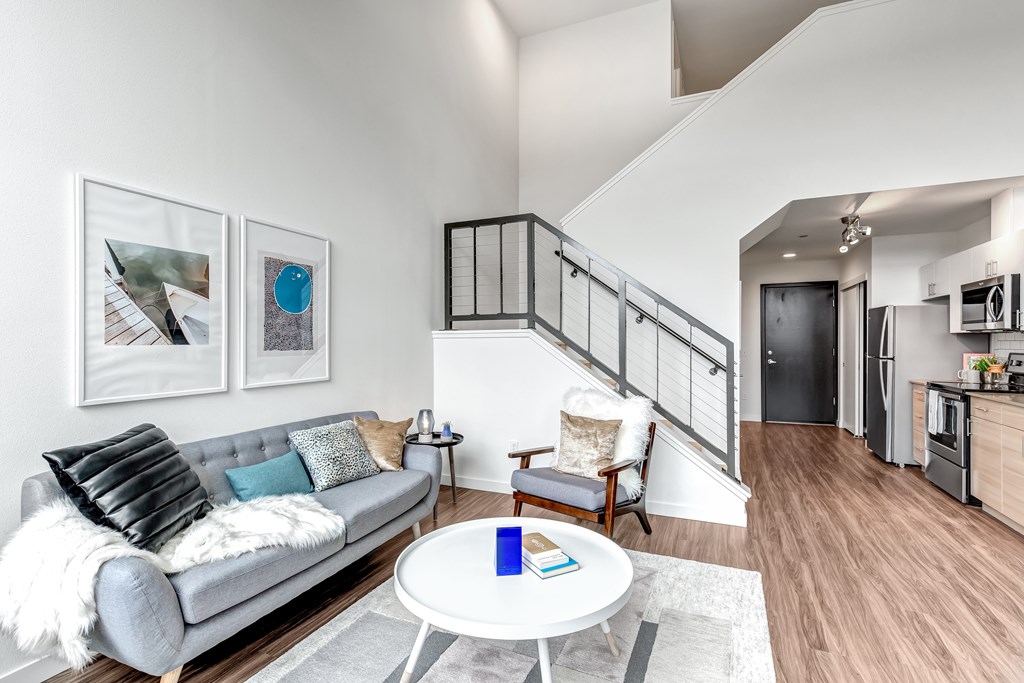 A living room with a grey couch and a white coffee table.