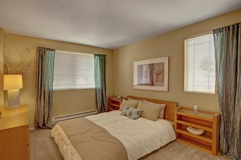 A bedroom with a large bed and a nightstand.