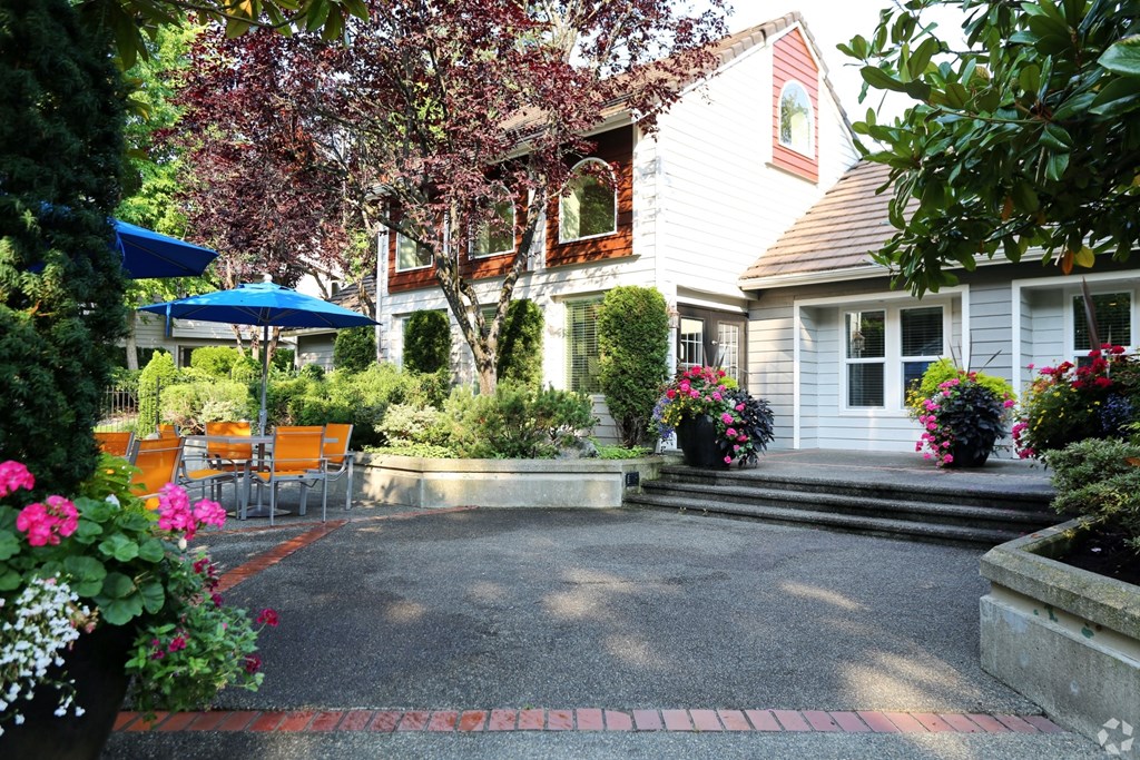 Fulton's Crossing and Landing Apartments  patio and yard of a white house with a patio table and chairs
