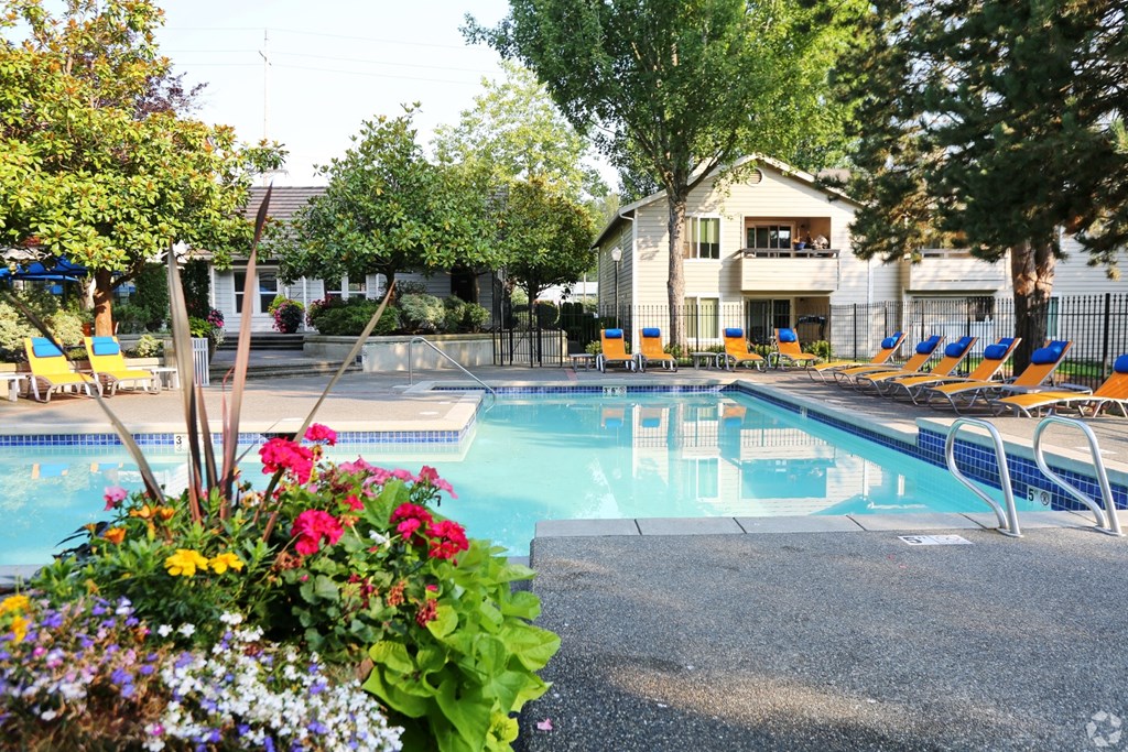 Fulton's Crossing and Landing Apartments swimming pool with chairs and flowers around it
