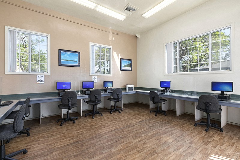 a computer lab with a row of computers on a table