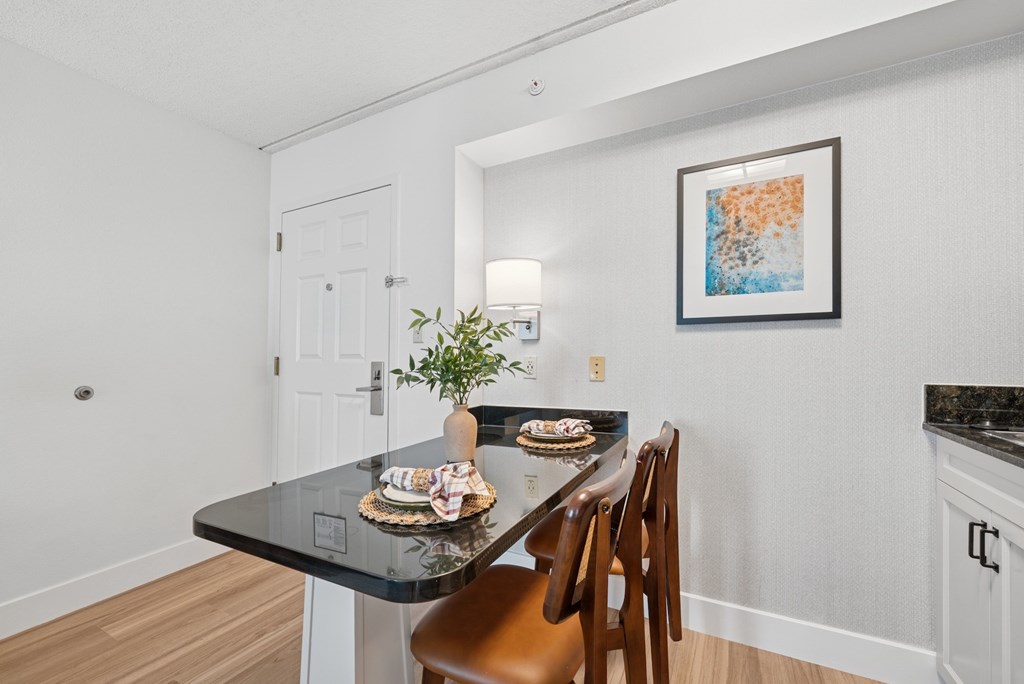 A dining table with a plant and a cake on it.