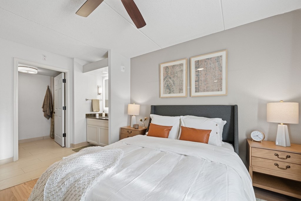 A bedroom with a large bed and a ceiling fan.