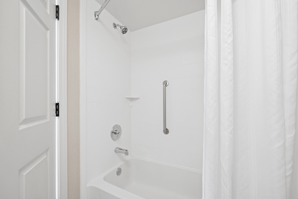 A white bathroom with a tub and shower.